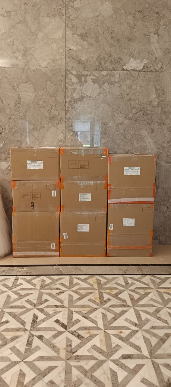 Labelled cartons packed and stacked in a building lobby for office shifting in Ghatkopar
